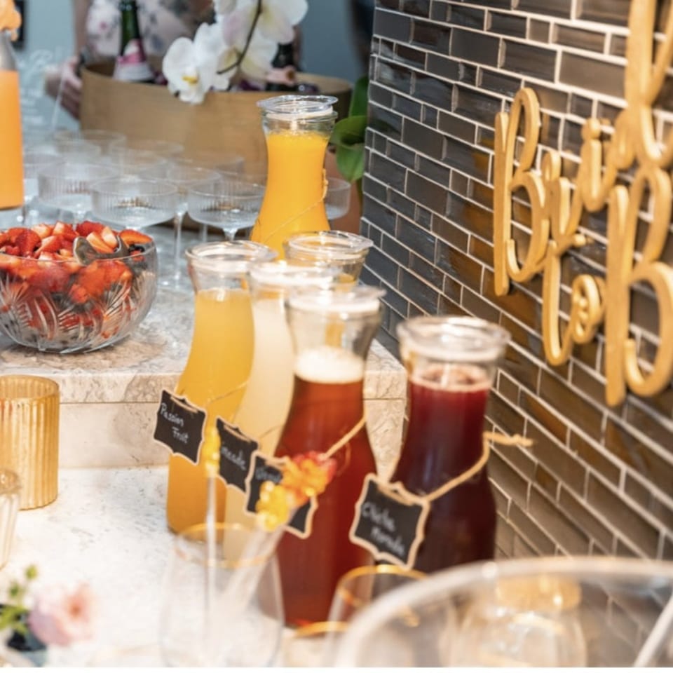 Peruvian beverages like Chicha Morada and Passion Fruit juice in glass bottles, with a bowl of strawberries.