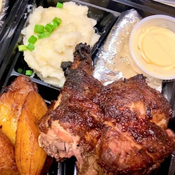 Inka Chicken! Peruvian meal with roasted chicken, potato wedges, mashed potatoes, and sauce in a to-go container.