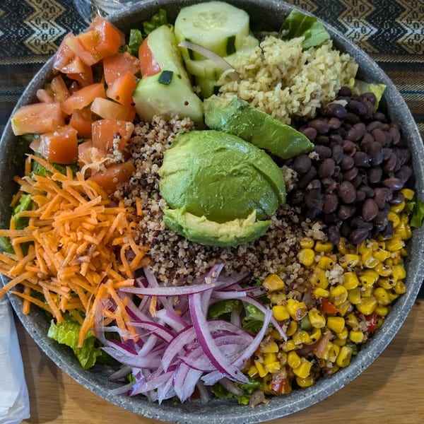 A vibrant Inka Chicken! Peruvian salad bowl with quinoa, avocado, corn, black beans, and vegetables.